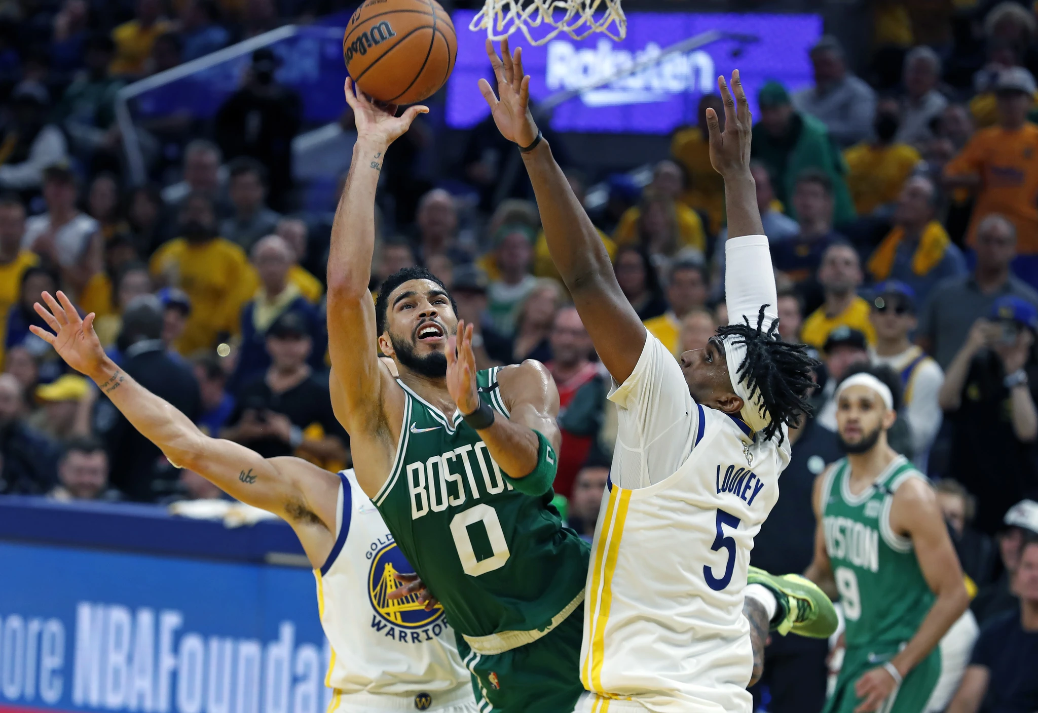 Celtics forward Jayson Tatum tries to get to the basket against Warriors center Kevon Looney on Sunday in Game 2 of the NBA Finals.  (Jim Davis/The Boston Globe via Getty Images)