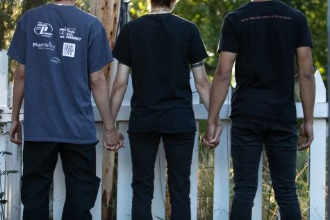 Three people line up holding hands